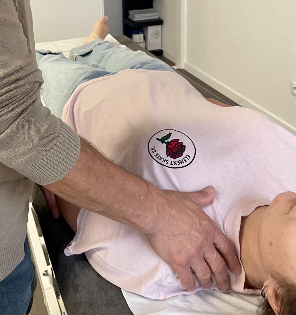 Séance d'ostéopathie tissulaire sur le dos d'une patiente